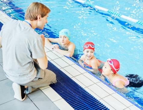 Photographie d'enfants et d'une encadrante à la piscine illustrant le BPJEPS